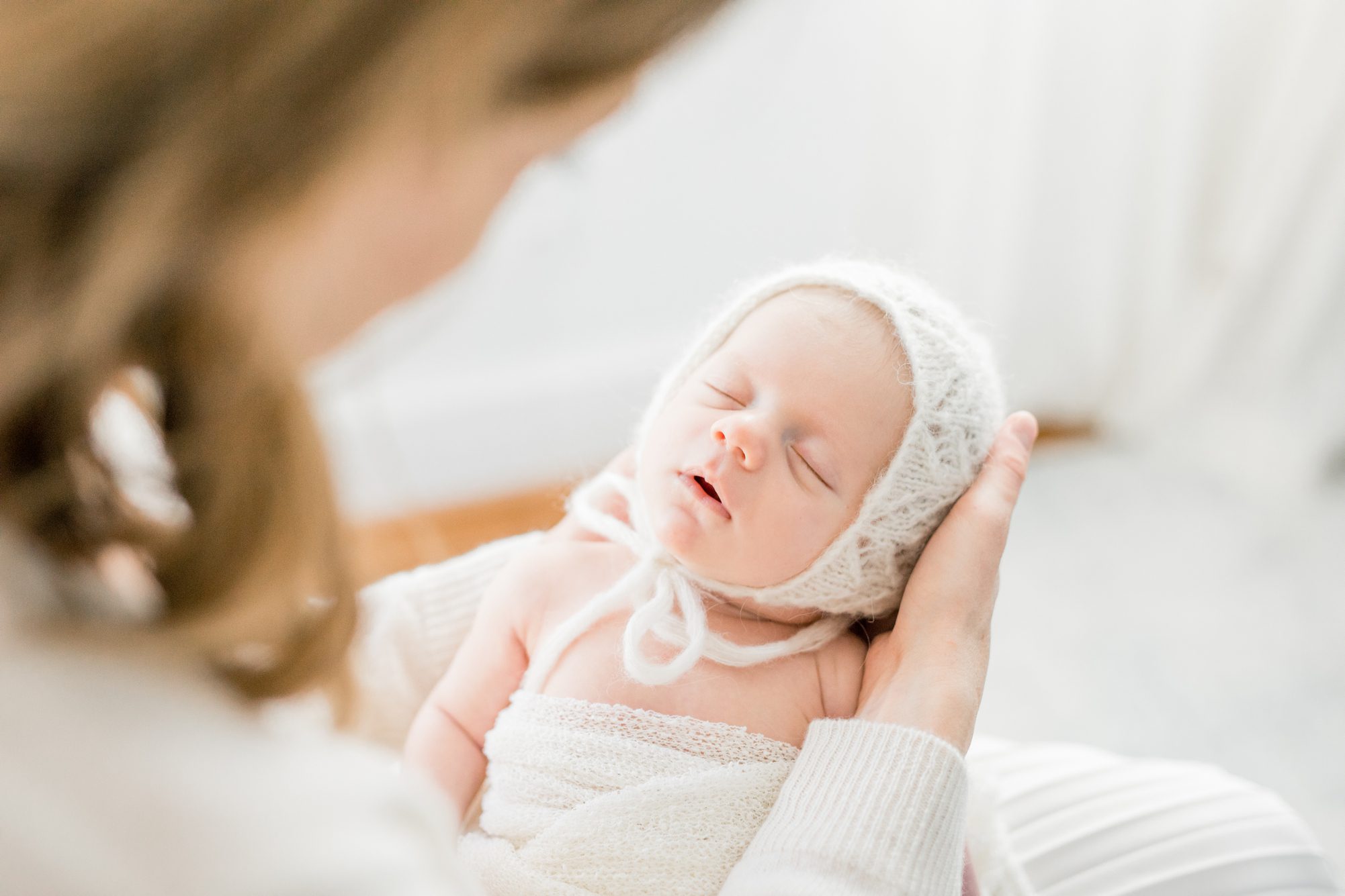 Portrait of newborn wearing bonnet. Photo by LRG Portraits.