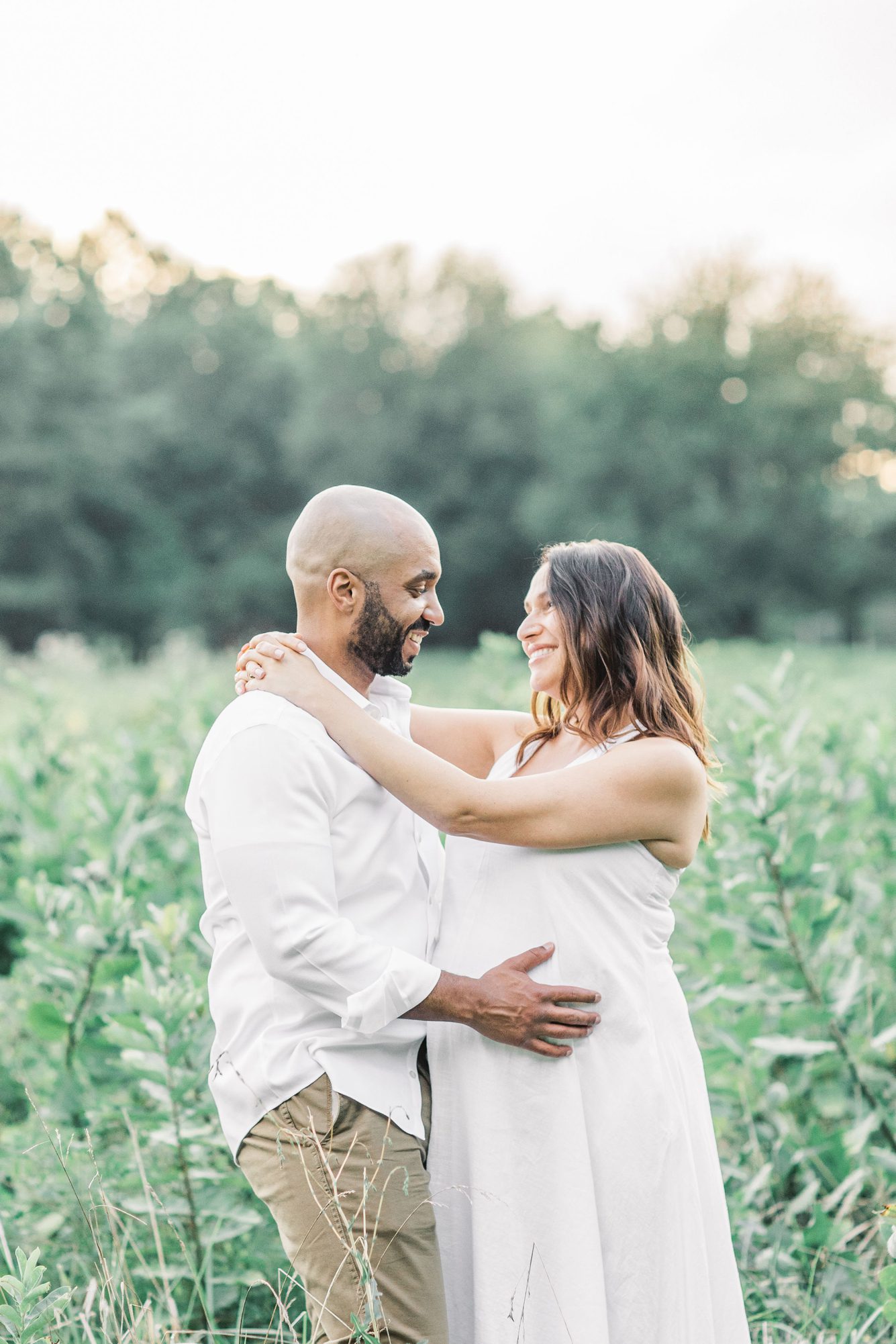 MOm and Dad hugging during maternity session at Rock Creek Park. Photo by Washington DC maternity photographer, LRG Portraits.