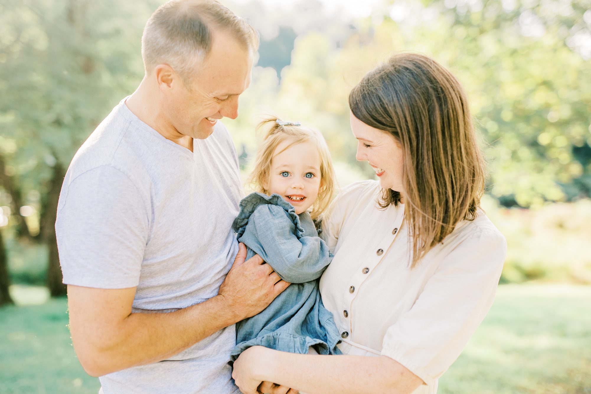 Parents smiling at toddler during family session. Photo by LRG Portraits. WASHINGTON DC FAMILY PHOTOGRAPHY