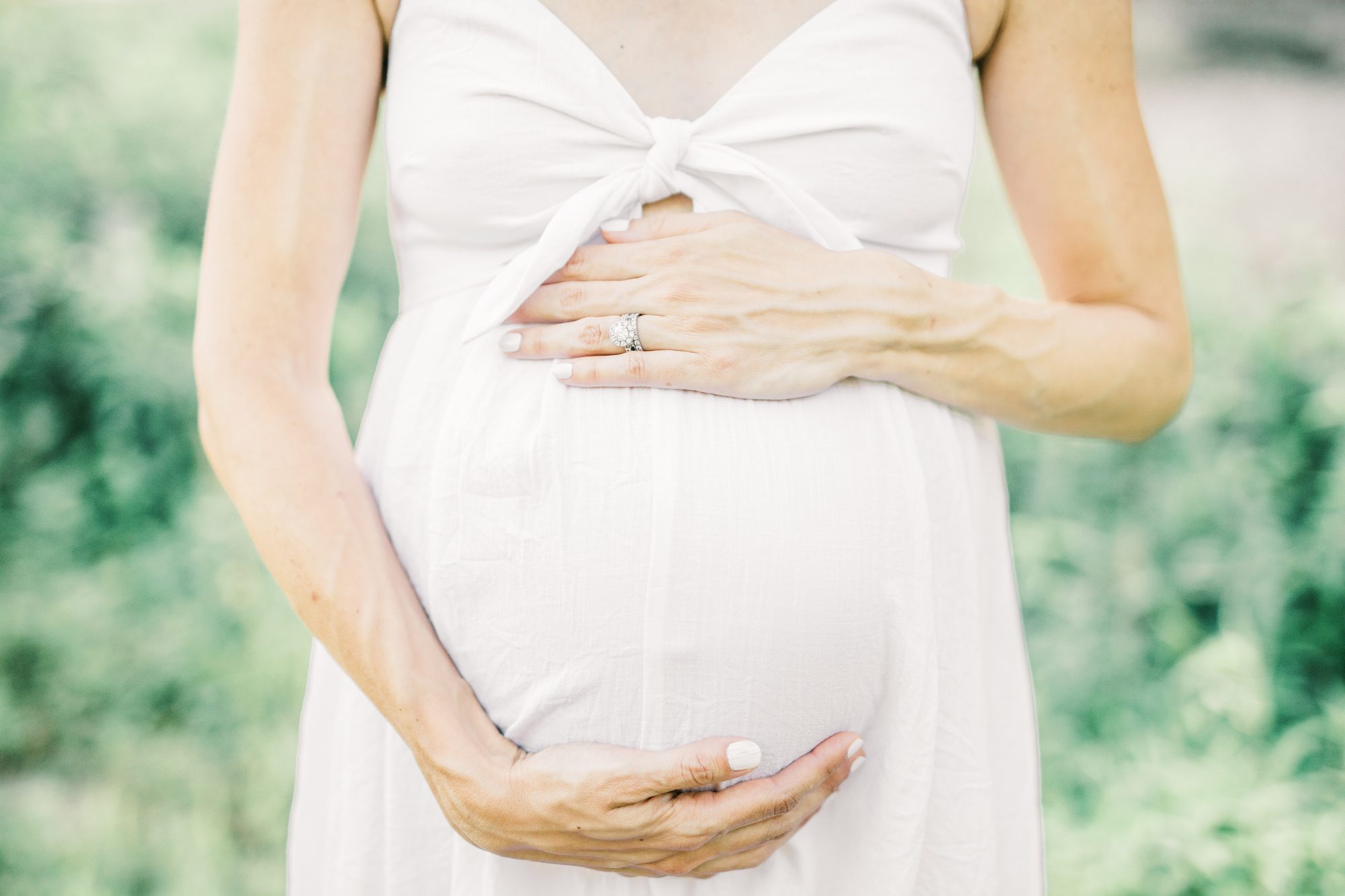 Closeup of baby belly during maternity session by the Potomac River in Washington DC. Photo by LRG Portraits.