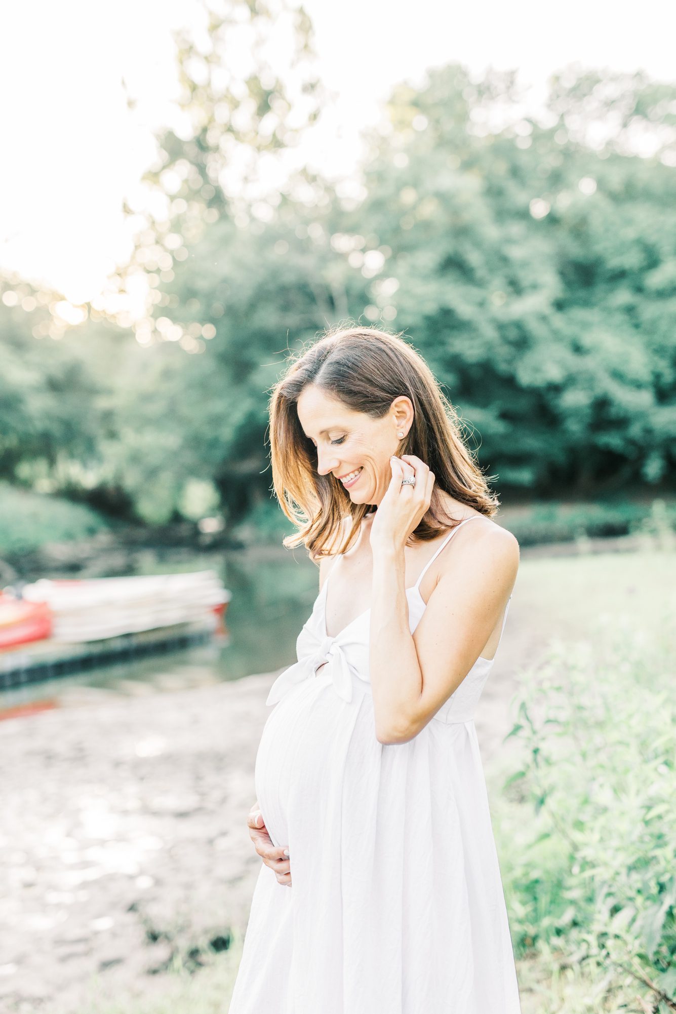 Mom smiling at baby bump during Washington DC maternity session. Photo by LRG Portraits.