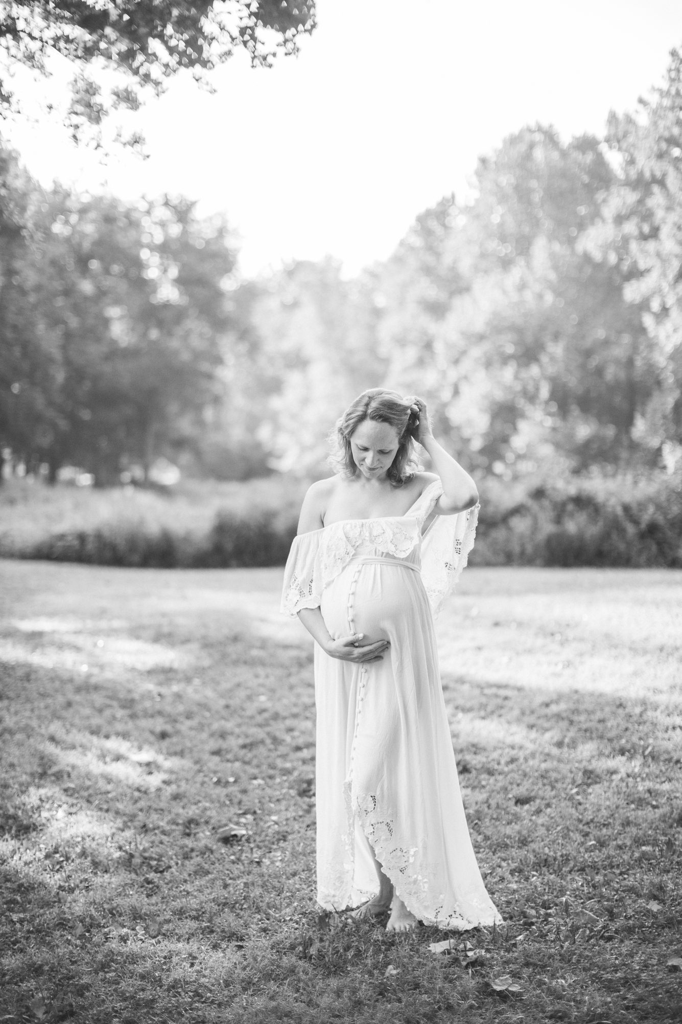 Stunning black and white portrait from maternity session of Mom looking at bump. Photo by LRG Portraits.