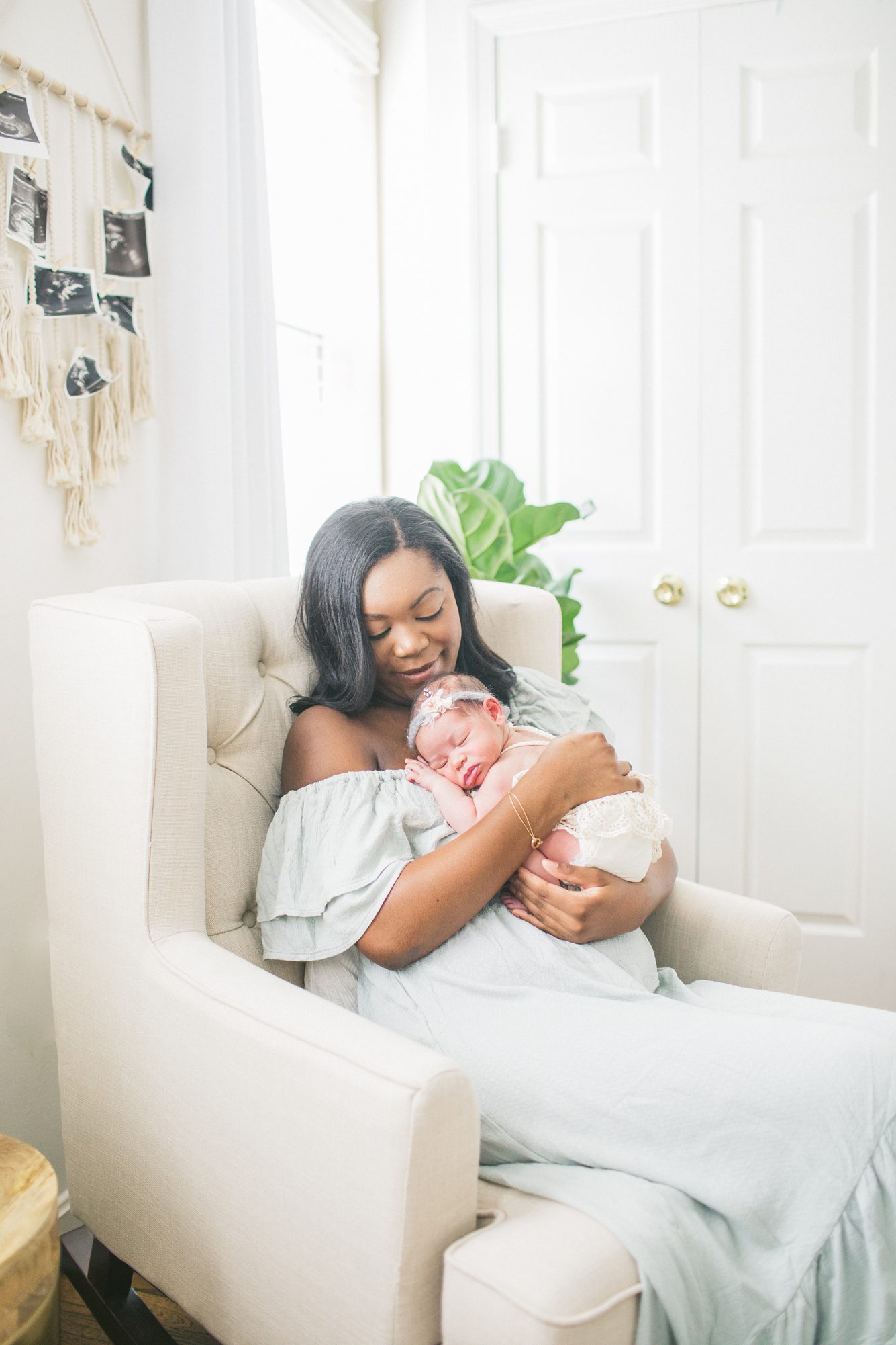 Mom holding baby in rocking chair during in home lifestyle newborn session in Washington DC. Photo by LRG Portraits.