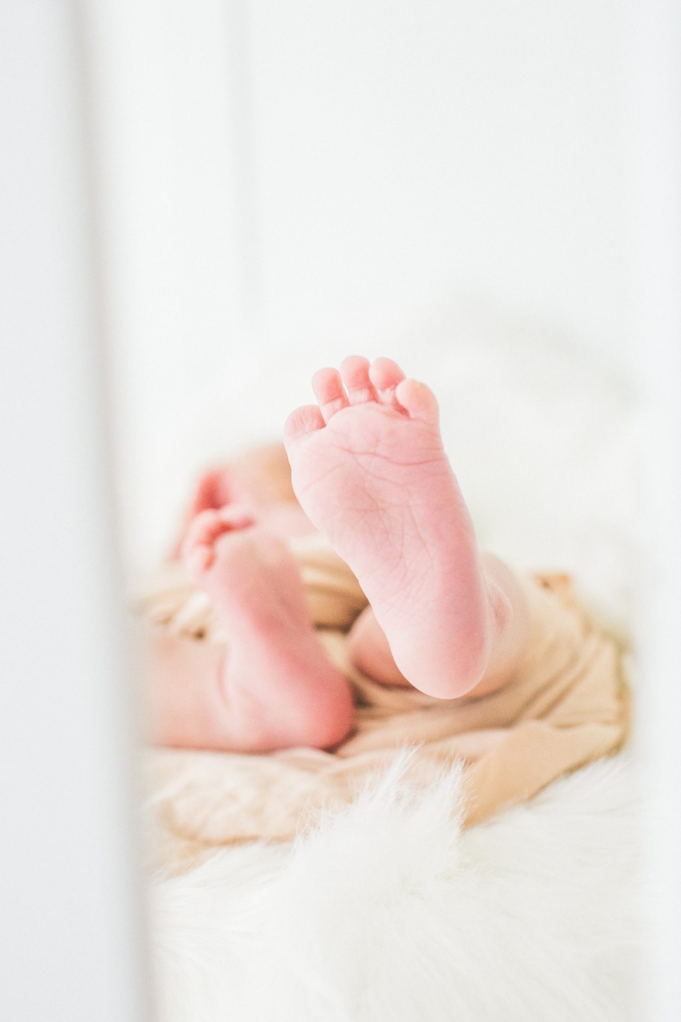 Closeup of newborn toes in crib. Photo by Washington DC newborn photographer, LRG Portraits.