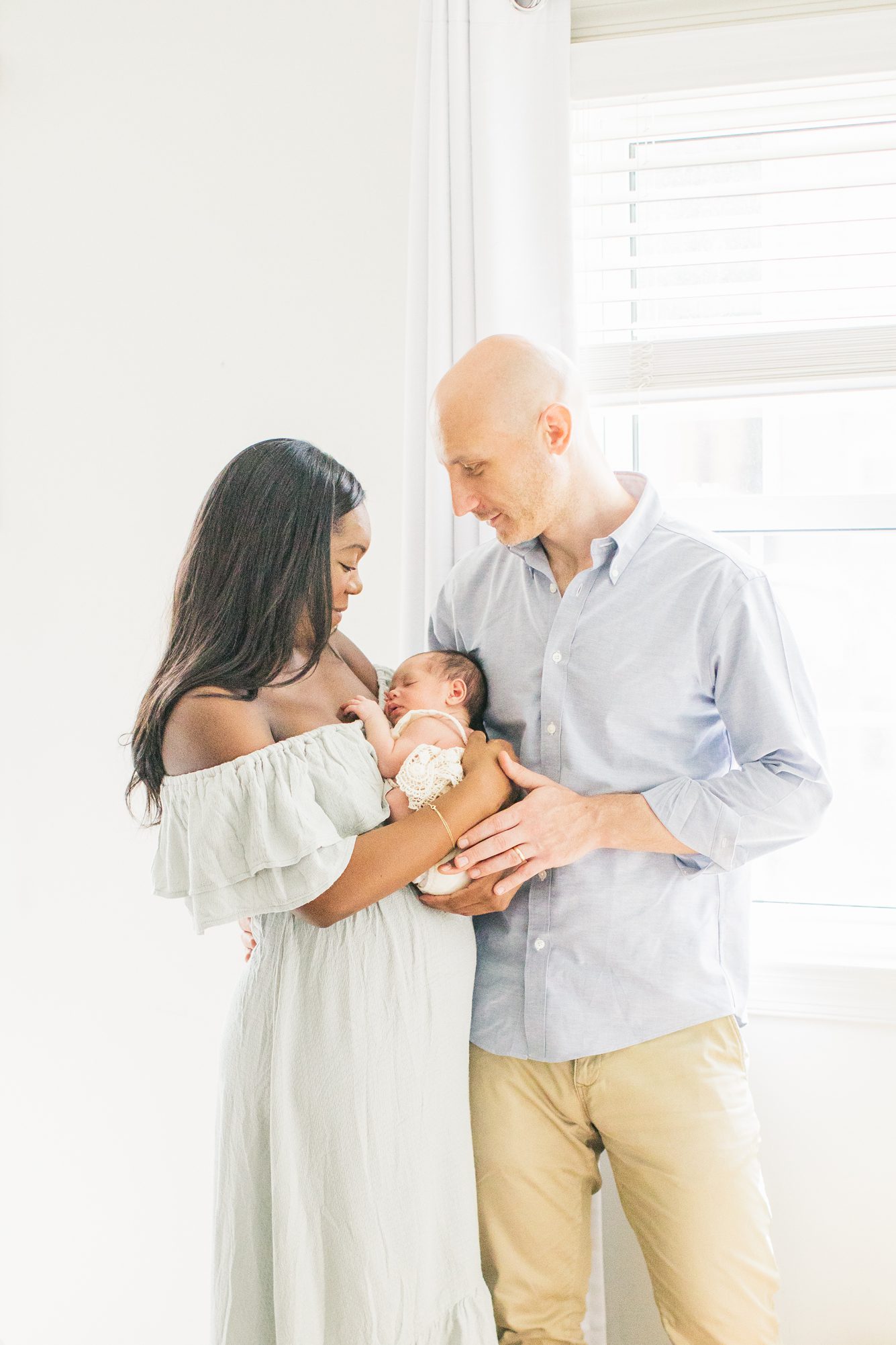 Sweet moment between Mom and Dad with baby during in home lifestyle newborn session in Washington DC. Photo by LRG Portraits.