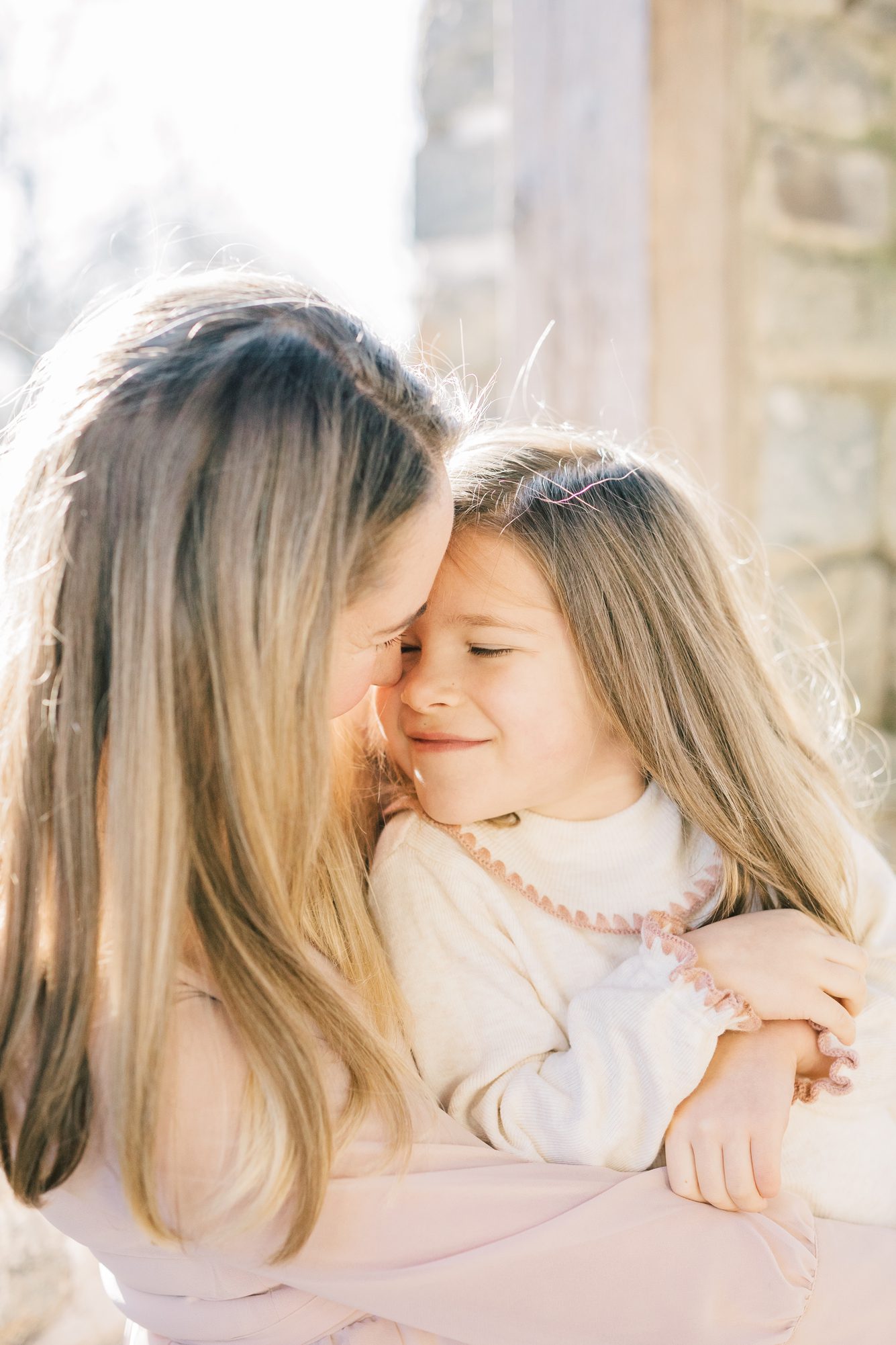 Closeup of Mom hugging daughter. Photo by LRG Portraits.