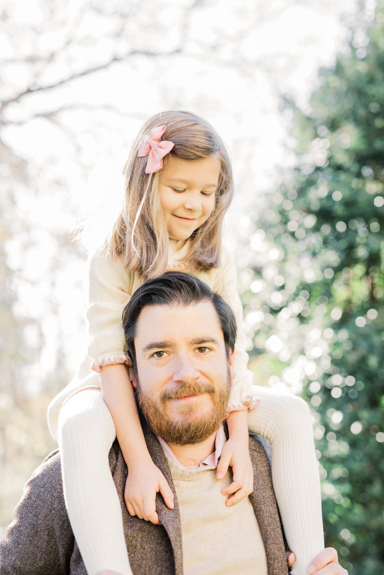 Daughter on Dad's shoulders during family photo session. Photo by LRG Portraits.
